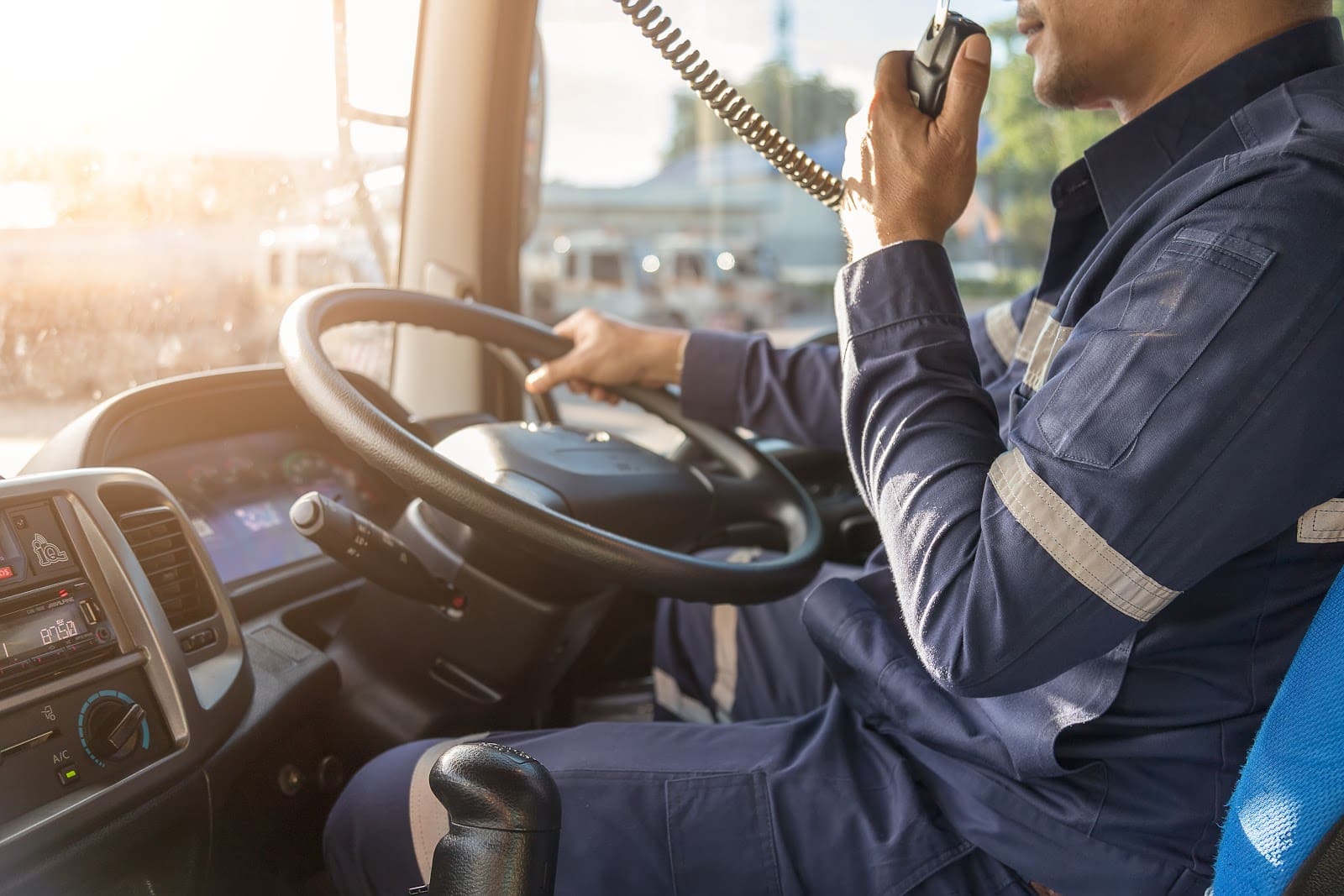 Man driving speaking into PA system.